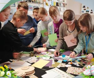 Uczniowie kompletują elementy do wykonania kartki świątecznej