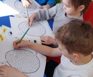 Na zdjęciu widoczne są dzieci rozwiązujące labirynt.