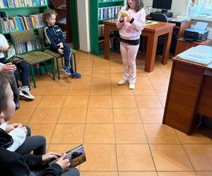 Na zdjęciu widoczne są dzieci podczas lekcji bibliotecznej.