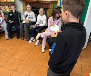 Na zdjęciu widoczne są dzieci podczas lekcji bibliotecznej.