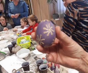 Na zdjęciu widoczne są dzieci i dorośli podczas warsztatów wielkanocnych.