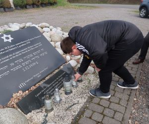 Uczeń stawiający znicz przy pomniku