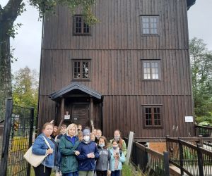 Uczniowie z nauczycielami przy starym drewnianym młynie wodnym w Bondyrzu