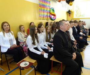 Dyrektor szkoły i nauczyciele siedzą na widowni