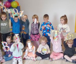 Zdjęcie przedstawia dzieci pozujące do zdjęcia z napisem Tydzień bibliotek.