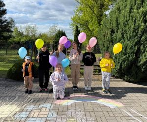 Zdjęcie przedstawia grupę dzieci stojących na świeżym powietrzu.