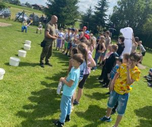 Pracownik straży granicznej opowiada uczniom o pracy psa tropiącego