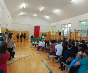 Uczniowie i ich rodzice słuchają przemowy pani Dyrektor