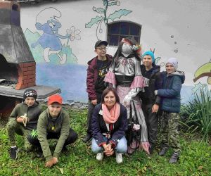 Pięciu chłopców i wychowawczyni przy manekinie przebranym za kobietę