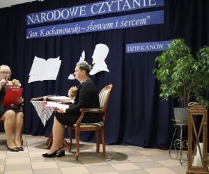 Na zdjęciu widoczne są dwie czytające kobiety, na tle udekorowanej ściany.