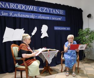 Na zdjęciu widoczne są dwie czytające kobiety, na tle udekorowanej ściany.