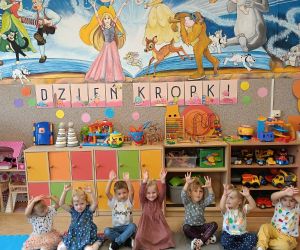 Przedszkolaki na dywanie przy wspólnie wykonanym plakacie