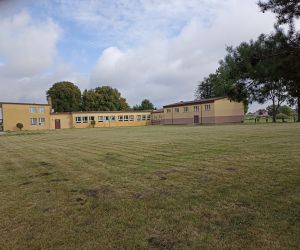 Dzieci zbierają śmieci na boisku szkolnym.