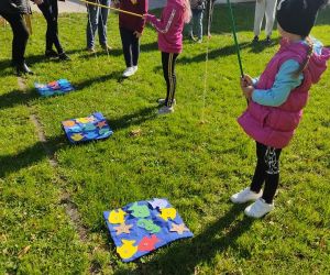 Dzieci na świeżym powietrzu grają w gę łowienie rybek.