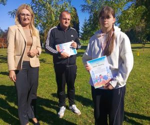 Dyrektor szkoły, nauczyciel wychowania fizycznego i uczennica klasy szóstej, zdobywczyni miejsca pierwszego