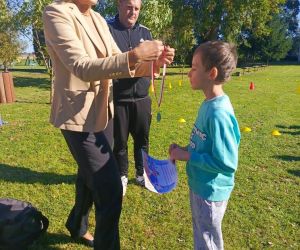 Dyrektor szkoły i nauczyciel wychowania fizycznego wręczają dyplom i medal za drugie miejsce uczniowi klasy trzeciej