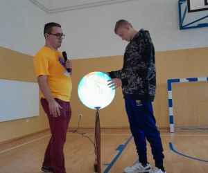 Prowadzący i uczeń klasy siódmej przy globusie