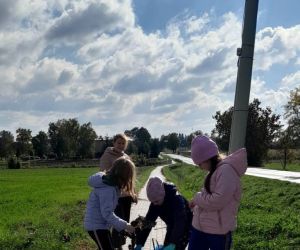 Trzy uczennice wrzucają śmieci do worka