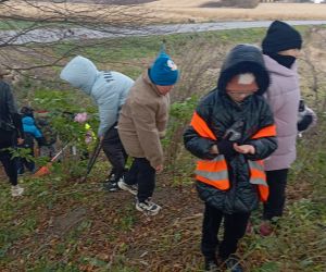 Uczniowie sprzątają mogiłę