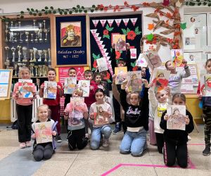 uczniowie z portretami Patrona na wspólnym zdjęciu