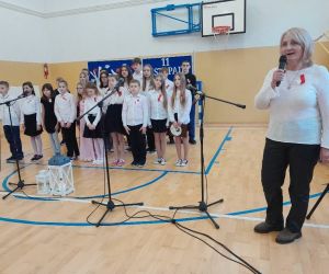 Pani wicedyrektor przy mikrofonie, za nią stoją uczestnicy apelu