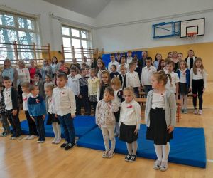 Uczniowie i nauczyciele szkoły podczas śpiewania hymnu państwowego