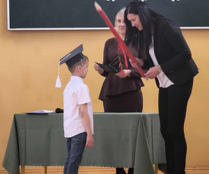 Pani Dyrektor pasuje ucznia symbolicznym ołówkiem.