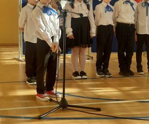 Uczeń klasy pierwszej recytuje przy mikrofonie