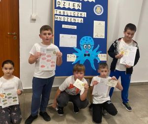 Kilkoro uczniów stoi przy dekoracji związanej z Dniem Tabliczki Mnożenia