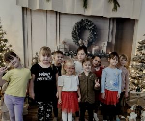 Zdjęcie grupowe dzieci z oddziałów przedszkolnych w świątecznej aranżacji.