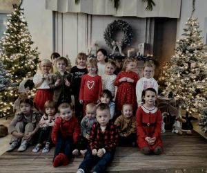 Grupa dzieci pozująca w świątecznej dekoracji.