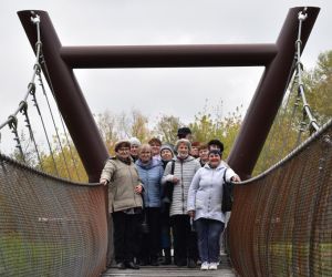 Kryłów. Grupa ludzi wchodzi na wiszącą kładkę nad starorzeczem Bugu