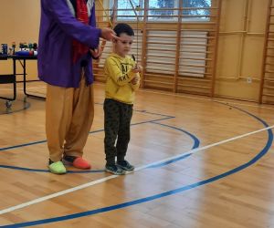 Klaun pokazuje przedszkolakowi jak używać wędki