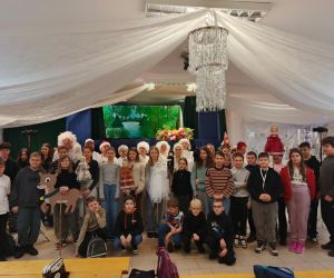 Uczniowie pozujący do zdjęcia z aktorami po zakończonym spektaklu.