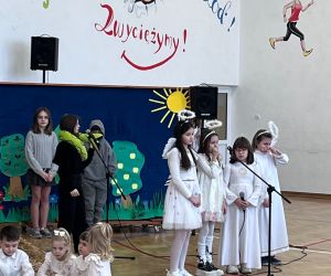 dziewczynki w strojach aniołków śpiewają kolędy