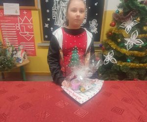 Uczennica trzyma dyplom i nagrodę