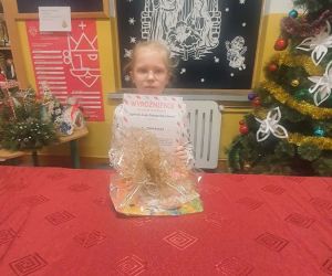 Uczennica trzyma dyplom i nagrodę