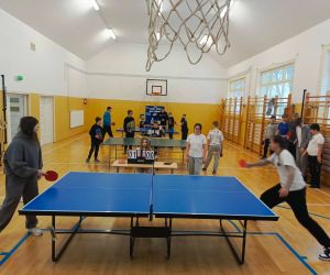 Uczniowie rozgrywają mecze tenisa stołowego w sali gimnastycznej - na pierwszym planie widoczne dwie grające szóstoklasistki