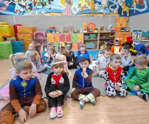 Przedszkolaki w kolorowych przebraniach podczas słuchania baśni