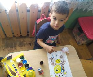 Chłopiec maluje farbami