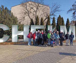  Grupa uczniów podczas wspólnego zdjęcia przy napisie „Chełm”.