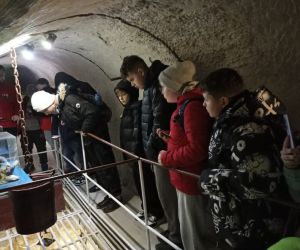  Uczniowie zwiedzają podziemne korytarze Chełmskich Podziemi Kredowych i oglądają wystawę.