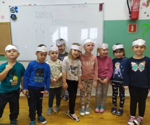 Dzieci pozują do zdjęcia w opaskach super przedszkolaka