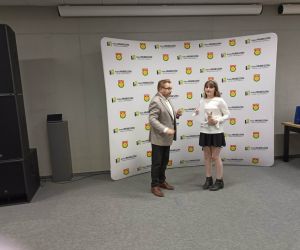 Uczennica otrzymuje dyplom oraz nagrodę za udział w konkursie wiedzy pożarniczej.