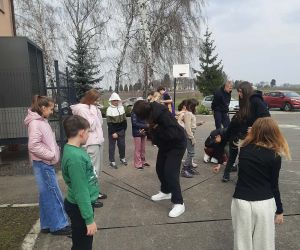 Uczniowie grają w gumę na placu szkolnym