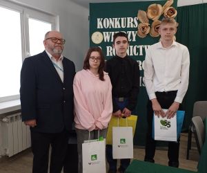 Uczniowie reprezentujący naszą szkołę z dyrektorem szkoły rolniczej na tle tablicy dekoracyjnej