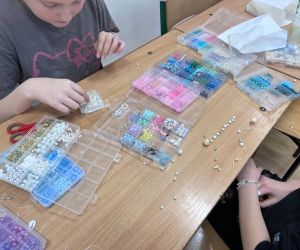 uczennica robi bransoletkę z koralików