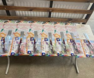 Dyplomy, podziękowania i upominki umieszczone na stoliku