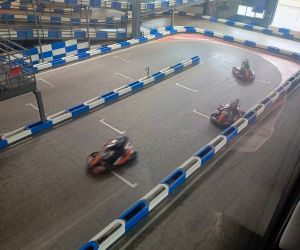 Uczniowie jadą gokartami po torze