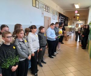 Uczniowie ustawieni na szkolnym korytarzu podczas apelu.